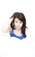 Naklejka premium Portrait of a tired young woman sitting on her bed