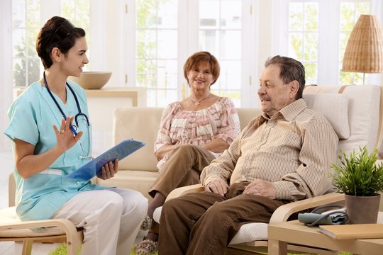 Nurse talking to elderly patients at home