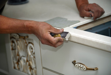 Man hand performs polishing kitchen furniture