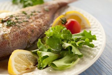 salad and fish on dish selective focus on salad