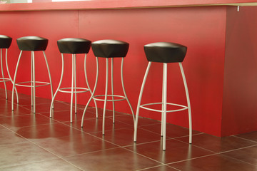 Black stool in interior of bar on ceramic floor