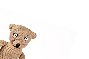 Teddybaer schaut aus einer Ecke raus