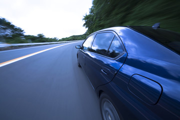 Obraz premium Po górskiej drodze samochód porusza się z dużą prędkością