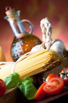 Raw pasta with tomato, basill, garlic and olive oil close up