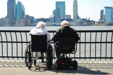 Senior couple sitting on a wheelchair and a scooter © JohnKwan