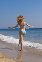 Naklejka premium Young graceful woman goes on coast of ocean