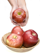 Hands stretch apple and bowl with apples