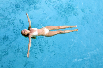 Young woman smiles, swiming in ocean, Maldives..