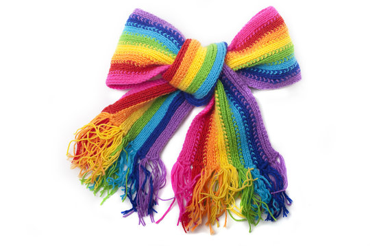 The image of a bright rainbow knitted scarf