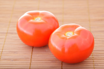 Red salad and tomato on brown bamboo napkin