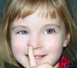 blond little girl portrait finger in nose gesture