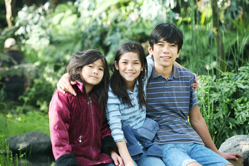 Three children sitting outdoors