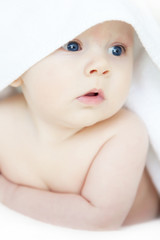 adorable baby after bath, wrapped in white towel