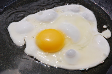 Macro closeup of an egg sizzling in a frying pan