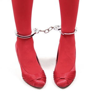 Restraint. Woman red legs in handcuffs
