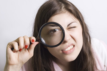 pretty young woman looking through magnifying
