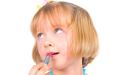 Cute little girl is using lipstick for a first time