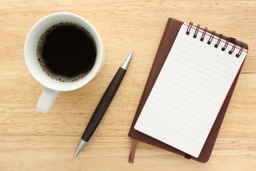 Black coffee,notebooks and pen on wood background