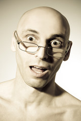 Shocked man looking over the top of his reading glasses