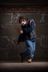 Obraz na płótnie Canvas Hip hop dancer in modern style over brick wall