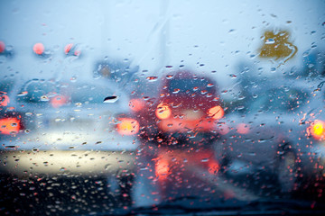 Car driving in a rain storm with blurred red lights - 22034659