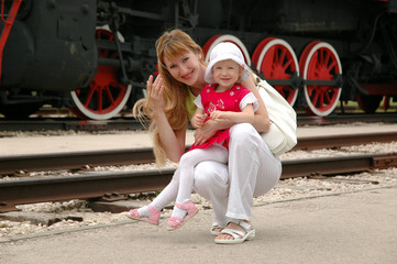 Woman with child beside locomotive