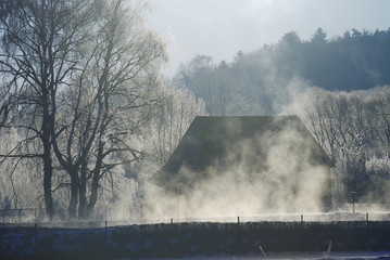 Foggy winter morning with an old house