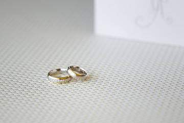 Two wedding rings and wedding invitation