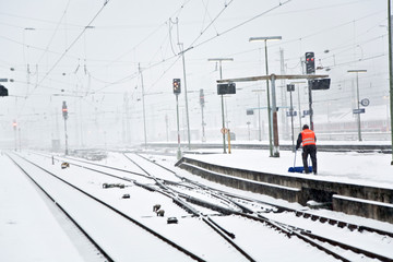 people moving snow in wintertime in station