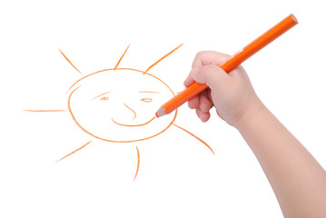 Childrens hand with pencil draws the sun