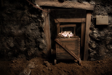 Fototapeta na wymiar stara kopalnia i wózek pełen błyskotliwych kamienie