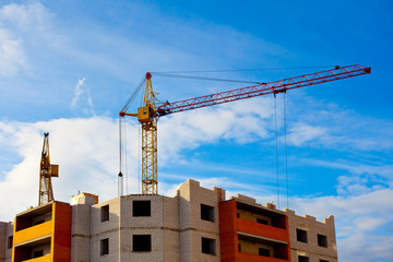 Two cranes and house construction