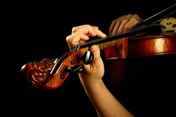 Musician playing violin isolated on black.