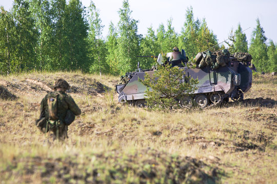 NATO army soldiers escort armored troop-carrier