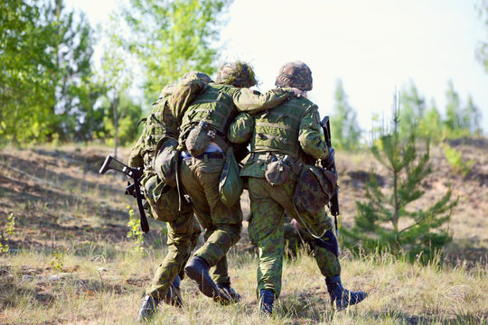 Two NATO Army soldiers escorted the wounded  soldier