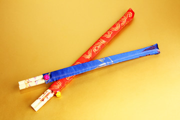 two sets of colorful chopsticks on gold