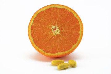 orangenhälfte mit vitamin c tabletten