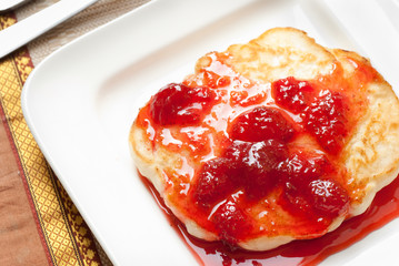A closeup of pancake with strawberry syrup