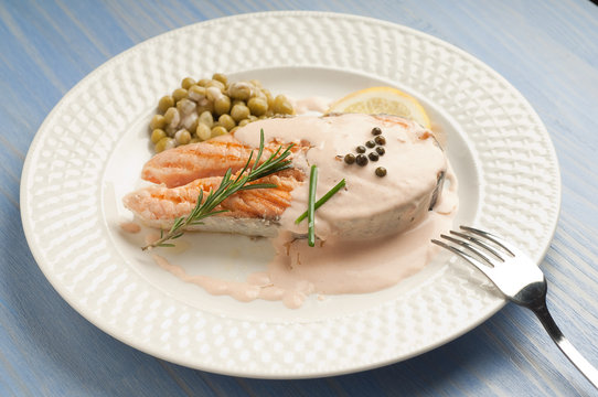 salmon with cream sauce on dish and fork
