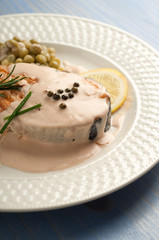 salmon with cream sauce on dish close up