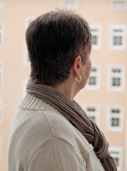 Seniorin steht einsam, deprimiert, traurig bei Fenster