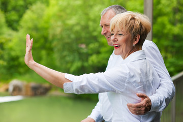 Glückliches Älteres Paar auf Brücke winkt zum Abschied