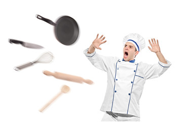 A view of flying kitchen utensils towards stunned chef