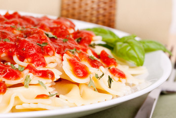 Bowtie pasta with  marinara sauce and basil garnish