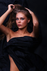 Fototapeta premium beautiful woman lies on black, the top view