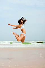 Naklejka premium happy woman jumping on the beach