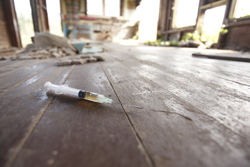 Syringe on the floor of an abandoned house.