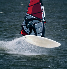 Windsurfer im Sprung mit fliegender Gischt