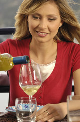 donna che versa il vino nel bicchiere