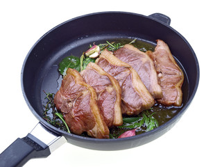 saddle of lamb, garlic & herbs roasting in a pan